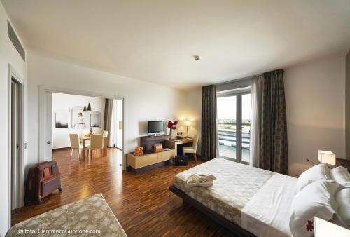 a bedroom with a large bed and a living room at Eureka Palace Hotel Spa Resort in Cassibile