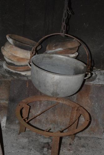 a metal pot on a stand next to a pile of bread at Friends House in Kutaisi