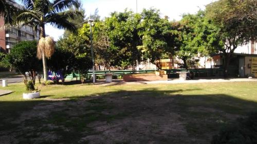 a park with palm trees and a bench in a park at Capao Canoa - Próximo Mar Centro in Capão da Canoa