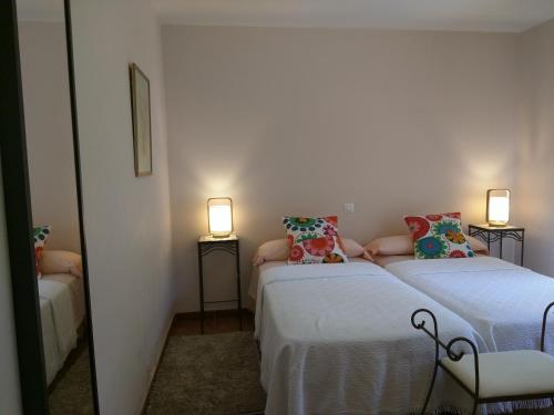 two beds in a room with two lamps on the sides at Puente Canto de Gredos in Arenas de San Pedro