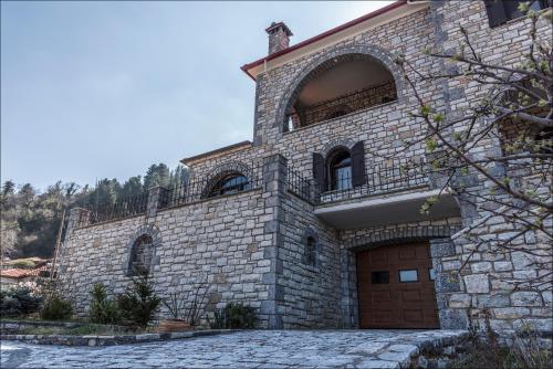 a large brick building with a brown door at Stone Mansion Anavryti, ΑΜΑ 20569 in Mystras