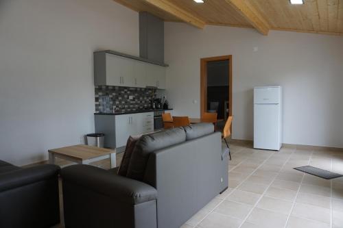 a living room with two couches and a kitchen at Quinta das Camélias in Tremês