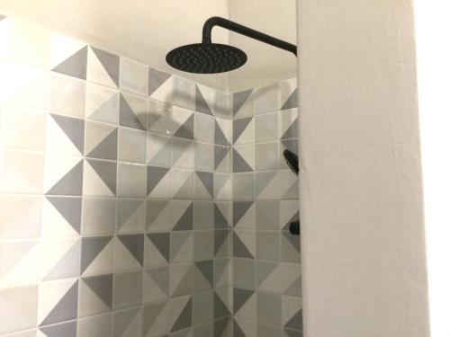 a bathroom with a shower with geometric tiles at Yellow House - Checkinhome in Boliqueime