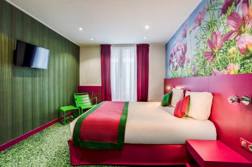 pokój hotelowy z dużym łóżkiem i telewizorem z płaskim ekranem w obiekcie Jardins de Montmartre w Paryżu