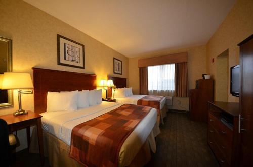 a hotel room with two beds and a television at Sheridan Hotel in Bronx