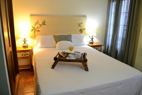 Un dormitorio con una cama con una bandeja de comida. en Hostal Toribio en Galaroza