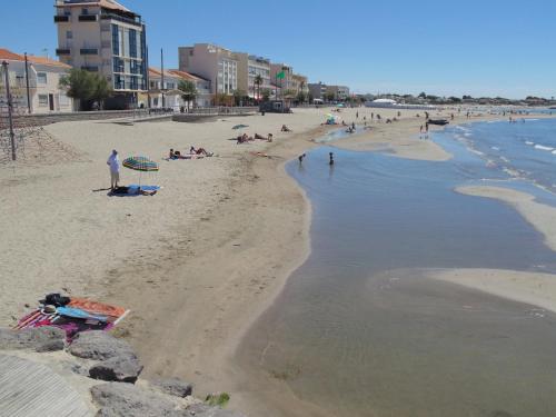 a group of people on a beach near the water at 3 bedroom apartment overlooking river in Agde