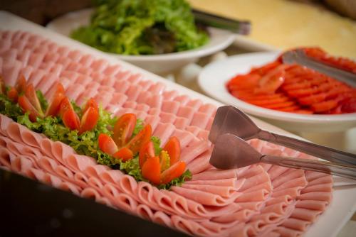 ein Teller mit Essen mit Fleisch und Gemüse darauf in der Unterkunft Grand Crucero Hotel in Puerto Iguazú