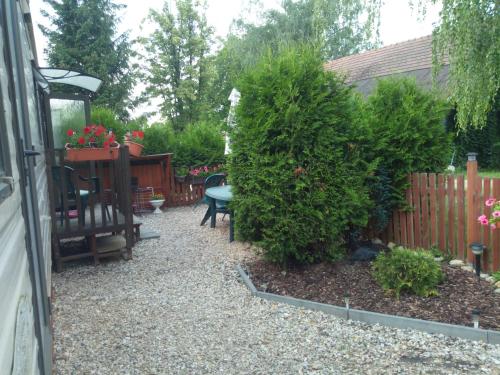 a garden with a fence and a table and some bushes at Ubytovani v mobilnim domku in Sobotka
