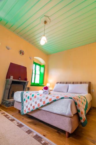 a bedroom with a large bed and a fireplace at Morfeas Guesthouse in Papigko