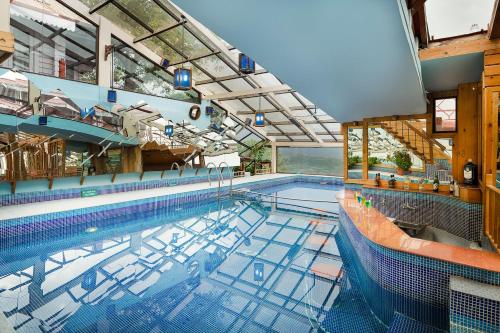 a large indoor swimming pool with a large poolvisor at The Chalets Naldehra in Shimla