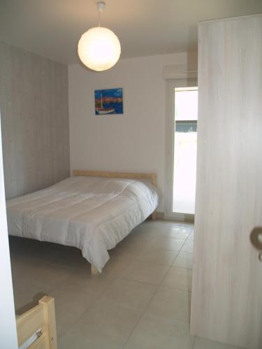 une petite chambre avec un lit et une fenêtre dans l'établissement Appartement Le Parc Saint Raphaël, à Saint-Raphaël