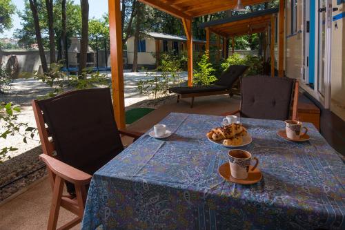 Mobile home - Kamp Olga في بنجول: طاولة زرقاء مع أكواب وصحن من الطعام عليها