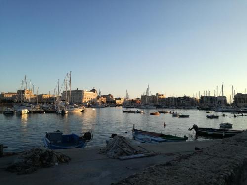 un puerto con barcos en el agua con un grupo de edificios en Aretè Guest House en Siracusa