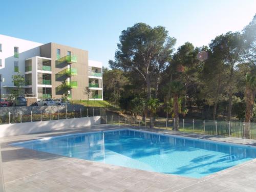 - une piscine en face d'un immeuble dans l'établissement Appartement Le Parc Saint Raphaël, à Saint-Raphaël