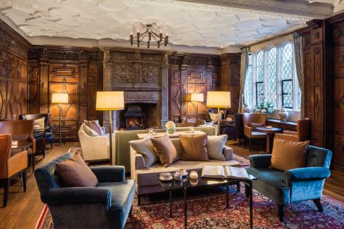 a living room with a couch and chairs and a fireplace at Eastwell Manor, Champneys Hotel & Spa in Ashford