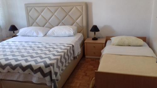 - une chambre avec 2 lits et une table de chevet avec 2 lampes dans l'établissement Apartment Mime Blata, à Vodice