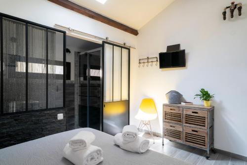 - une chambre avec des serviettes sur un lit et une télévision dans l'établissement Lyon Mon Amour B&B, à Lyon