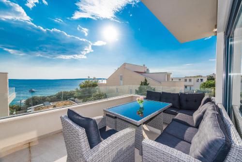 a balcony with chairs and a table and a view of the ocean at Luxury penthouse in Mandre