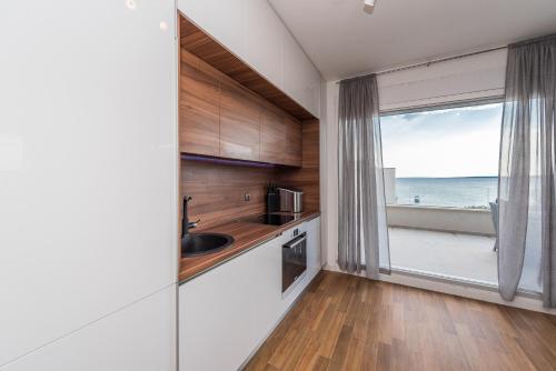 a kitchen with a large window with a view of the ocean at Luxury penthouse in Mandre