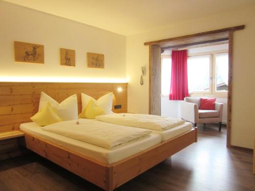 a bedroom with a large bed with yellow pillows at Hotel Alpensonne in Riezlern