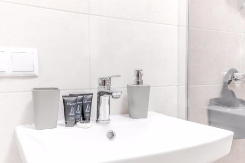 a white bathroom with a sink and a mirror at VIP apartment Blue Whale in Odesa