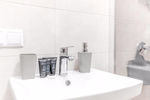 Un baño blanco con lavabo y espejo. en VIP apartment Blue Whale, en Odessa