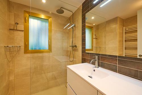 a bathroom with a sink and a shower and a mirror at Residence Velas Garden Pool Suite in S'Agaro