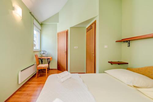 a bedroom with a bed and a table with a chair at Natali in Omiš