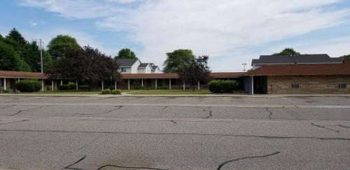 an empty parking lot in front of a building at Wolds Motel - Mt. Pleasant in Mount Pleasant