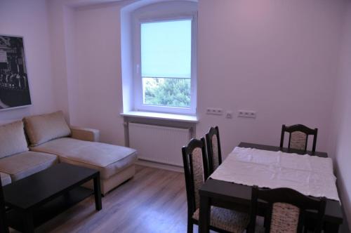 a living room with a couch and a table and a dining room at Apartamenty Centrum Słupsk in Słupsk