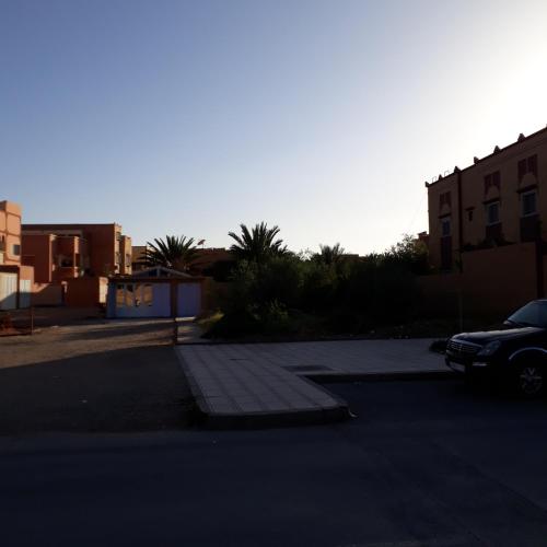a parking lot with a car parked on the street at Oasispalmares in Er Rachidia