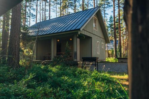 a small cabin with a porch in the woods at Peipsi Homestay in Kuru