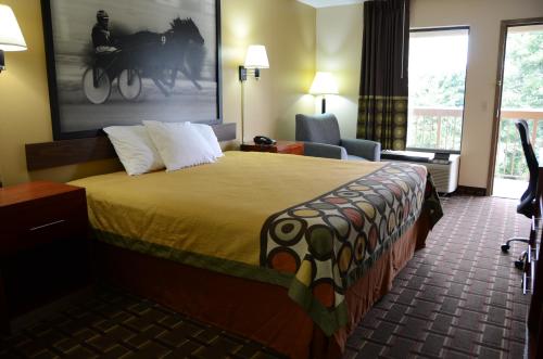 a hotel room with a bed and a chair at Super 8 by Wyndham Franklin Hwy 31 in Franklin