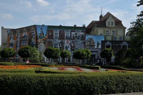 a large building with a garden in front of it at Apartamenty Centrum Słupsk in Słupsk