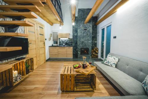 een woonkamer met een bank en een tafel bij Domki na Łazach in Uherce Mineralne