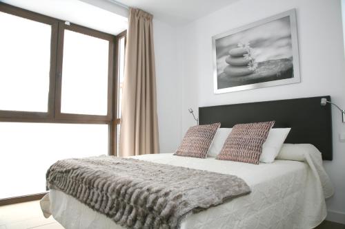 a bedroom with a large bed and a window at Apartamentos Balcón de Nerja - Adults Only in Nerja
