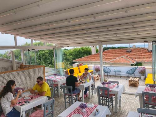 un grupo de personas sentadas en mesas en un patio en Alicante Hotel - Adult Only, en Bozcaada