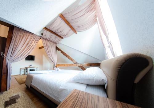 a bedroom with a bed and a window with curtains at Penthouse Apartment in Brčko