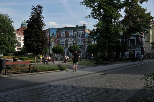 a person walking down a street in a park at Apartamenty Centrum Słupsk in Słupsk