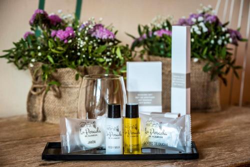 a table with some products on a table with flowers at Hotel La Posada De Alameda in Alameda del Valle