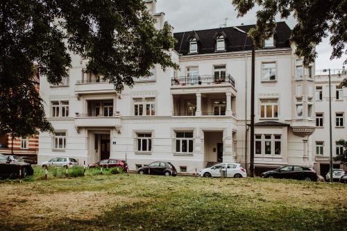 a large white building with cars parked in front of it at Śpij w Nysie Apartments in Nysa