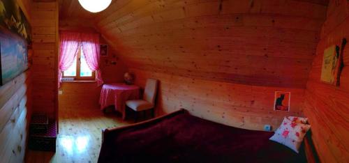 a room in a log cabin with a bed and a table at Sunnyside in Žabljak