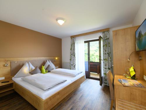 Schlafzimmer mit einem Bett, einem Schreibtisch und einem Fenster in der Unterkunft Haus Rainer in Mühlbach am Hochkönig