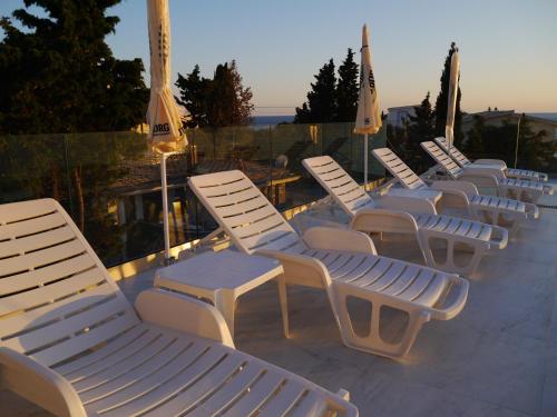 a row of white chairs sitting on a patio at CrystalSky in Dobra Voda