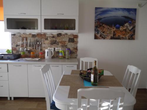 a kitchen with a table and chairs with a bottle of wine at CrystalSky in Dobra Voda