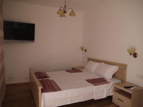 a bedroom with a bed and a flat screen tv at CrystalSky in Dobra Voda