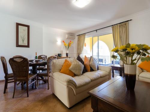 a living room with a couch and a dining room at Jardim da Meia Praia Apartment in Lagos