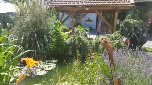 a garden with a wooden gazebo and flowers at La Grange en Champagne in Hermonville