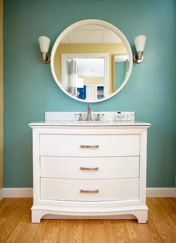 a bathroom with a white sink and a mirror at Breezeway Boutique Hotel in Westerly
